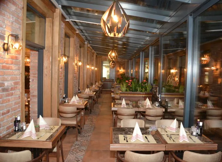 Der Wintergarten im Celina mit Backsteinwänden und Pendelleuchten