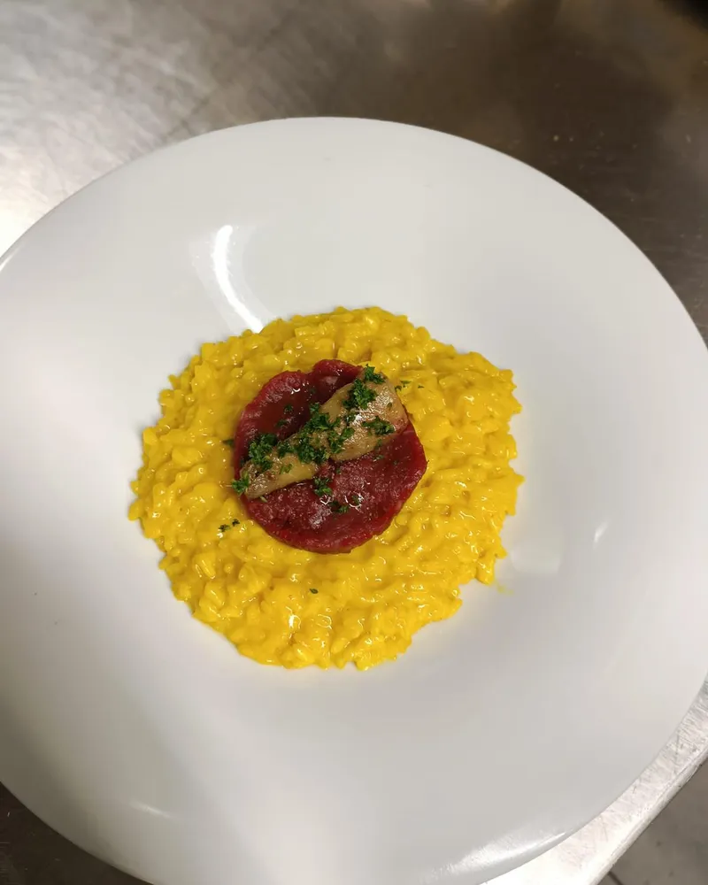 Safranrisotto mit Tatar auf weissem Teller