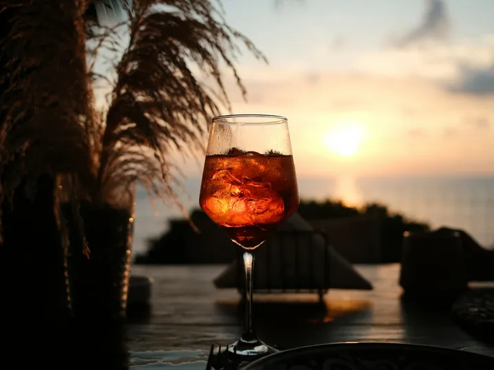 Aperol Spritz auf einer Terrasse am Wasser bei Sonnenuntergang