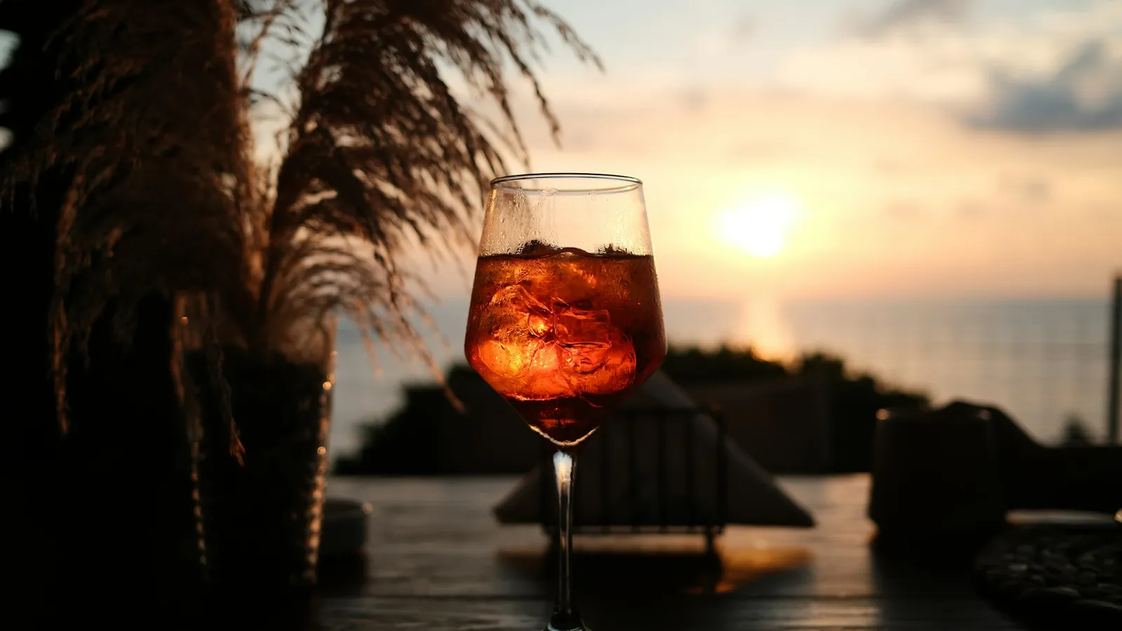 Aperol Spritz auf einer Terrasse am Wasser bei Sonnenuntergang