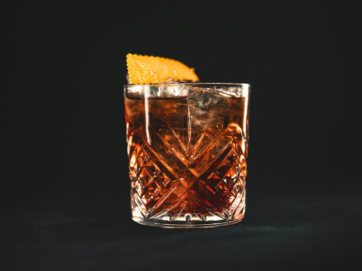 Negroni mit Orangenzeste auf einer Bar