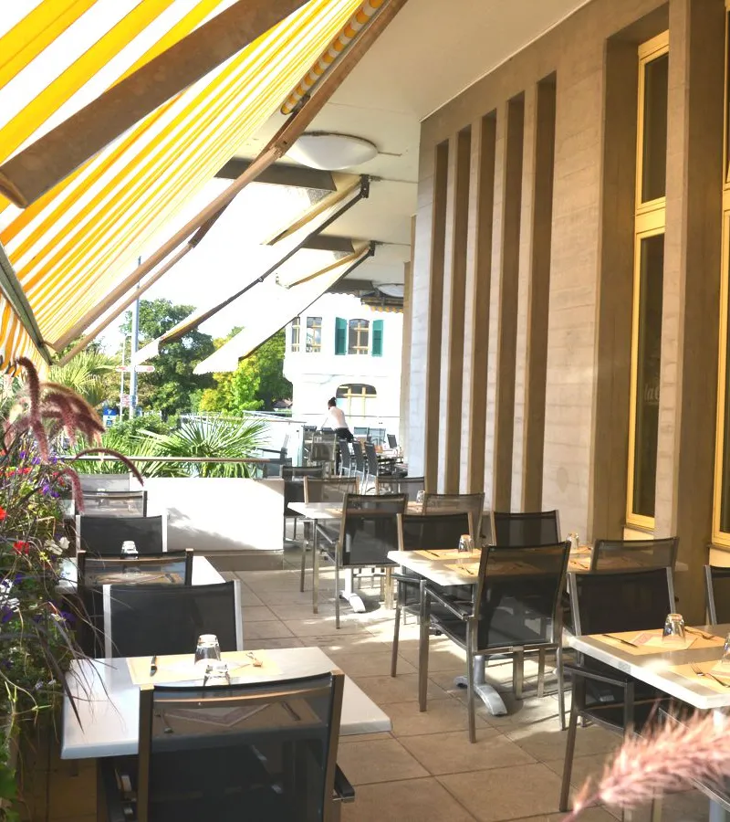 Die Terrasse des La Gioia unter einer gelb-weiss gestreiften Markise