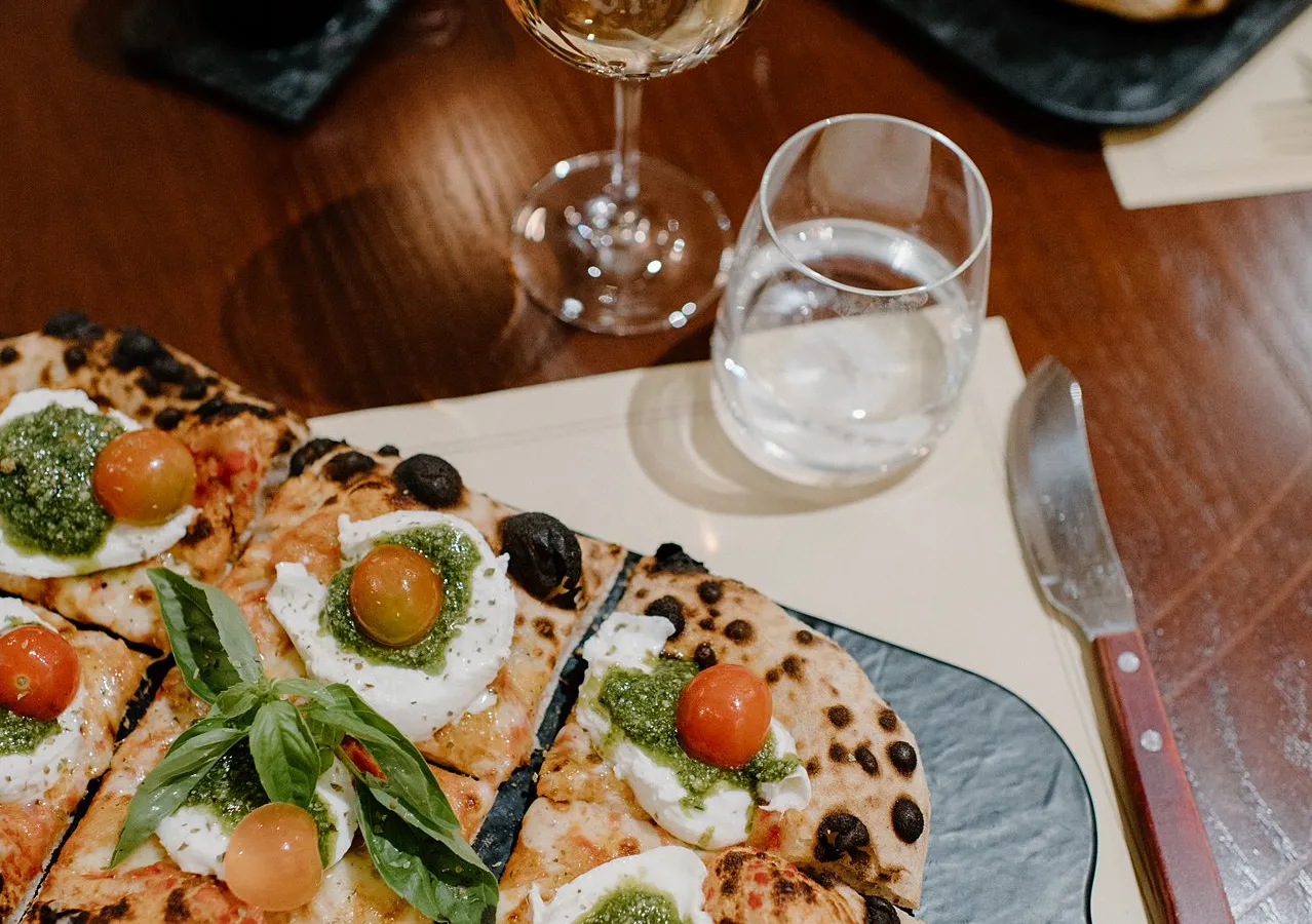 Pizzastücke mit Burrata und Pesto auf Schiefer
