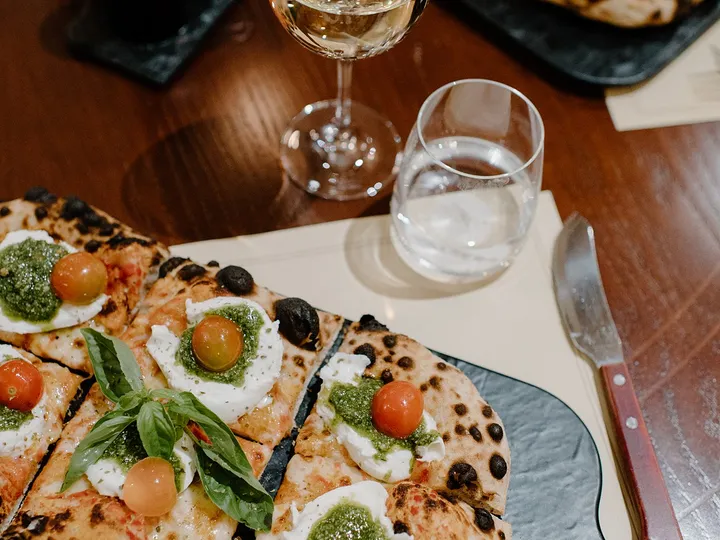 Pizzastücke mit Burrata und Pesto auf Schiefer
